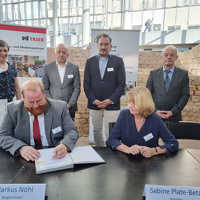 Sabine Plate-Batz unterzeichnet gemeinsam mit Markus Nöhl den Fortsetzungsvertrag. Im Hintergrund stehen Ramona Heeke, Rudolf Fries, Ivan Racic und Bernd Eckardt.