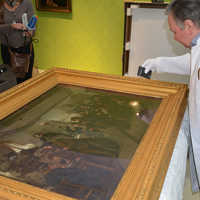 Dimitri Scher, Restaurator im Stadtmuseum, begutachtet ein Gemälde auf Transportschäden, bevor es an seinen Platz in der Ausstellung gehängt wird.