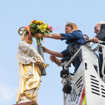 Weinkönigin Bärbel Ellwanger und Oberbürgermeister Wolfram Leibe legen der Petrusfigur auf dem Hauptmarkt per Drehleiter Blumen in den Arm.