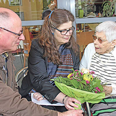 Horst Erasmy, Ortsvorsteher in Trier-West/Pallien, und Bürgermeisterin Angelika Birk gratulieren Margarete Petry. Neben einem Blumenstrauß überreichen sie Glückwunschschreiben von Ministerpräsidentin Malu Dreyer und OB Klaus Jensen sowie ein Geldgeschenk.