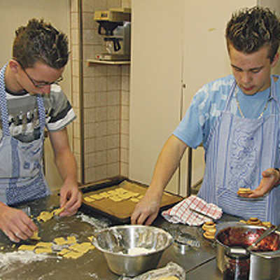 Markus (l.) und Maikel arbeiten konzentriert an den Weihnachtsplätzchen für das Jugendwerk Don Bosco.