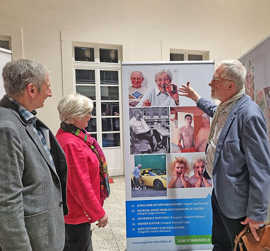 Alfred Bläser, Hubert Weis und Elisabeth Ruschel diskutieren über eines der Roll-ups bei der Wanderausstellung im Foyer der Stadtbücherei.