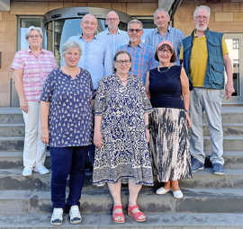 Gruppenbild mit neun Seniorinnen ud Sneioren, die auf Stufen stehen.