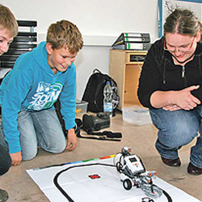 Stefan (13) und Lukas (11) beobachten ihren selbst programmierten Roboter beim Testlauf. Der Workshop „Roboter Forschungslabor spezial“ war der absolute Renner im KiWi-Programm.