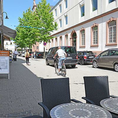 Nur im südlichen Teil der Neustraße gibt es derzeit noch öffentliche Parkplätze. Fußgänger, Radfahrer, Cafétische und Autos teilen sich den Straßenraum, in dem es zuweilen eng wird.