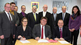 Mit Unterstützung des Notars Mathias Queck (vorn Mitte) unterzeichnen Bürgermeisterin Angelika Birk (vorne links) und SWT- Vorstand Arndt Müller (vorne rechts) den Vertrag für die regionale Bädergesellschaft.