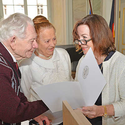 Elvira Garbes überreicht dem 92-jährigen Hvryyil-Dmitrovii Zavilenskyy und seiner Frau Teodoziya-Emiliy die Einbürgerungsurkunden. Das Ehepaar stammt aus der Ukraine.