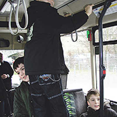 Schweißtreibende Sicherheitsübung: Auf einer „Räuberleiter“, die ihm ein Klassenkamerad aus der 5b baut, schwingt sich ein FWG-Schüler nach oben, um das Öffnen eines Sicherheitsfensters im Busdach zu testen.