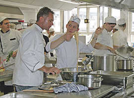 Lehrlinge aus Trier und Metz kochen gemeinsam in der Schulküche der Berufsbildenden Schulen: Während vorne frische Spätzle zubereitet werden, dampft dahinter der Topf mit Rotkohl.