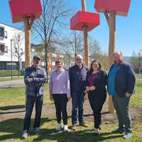 Kulturdezernent Markus Nöhl, Ortsvorsteherin Hasmik Garanian und drei Vertreter des Vereins Petrisberg Connect (v. r .) präsentieren die erneuerte Skulptur auf dem Grünstreifen an der Robert-Schuman-Allee.