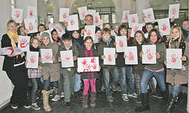 chülerinnen und Schüler des AVG, der Grundschule Kenn und Kinder der Kita Sirzenich übergeben Klaus Jensen (Mitte) die Zettel mit den Handabdrücken.