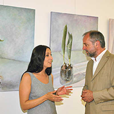 Die aus der Uraine stammende Künstlerin T. Libelle erläutert OB Klaus Jensen ihren Bilder-Zyklus „Flug der Papageitulpe“, der der neuen Ausstellung im „Trier-Zimmer“ den Namen gab.