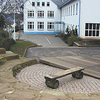 Zum erneuerten Grundschulhof in Feyen, der 2004 umgestaltet wurde, gehört auch eine kleine Holzbühne mit Zuschauerrängen aus Bruchsteinen. Direkt dahinter liegt der Bolzplatz