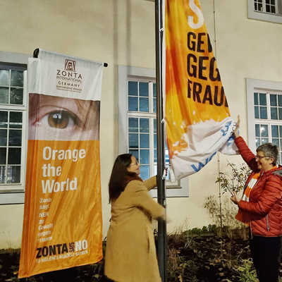 Frauenbeauftragte Angelika Winter (l.) und Christine Wirtz (Zonta Club) hissen am Aktionstag 25. November vor dem Rathaus das orange Banner für die weltweite UN-Kampagne gegen Gewalt an Frauen.