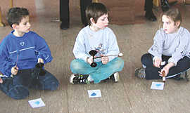 Spielerisch lernen Justin, Kevin und Denise (v. l. n.r.) aus der ersten Klasse der Grundschule Reichertsberg den Umgang mit einfachen Schlaginstrumenten.
