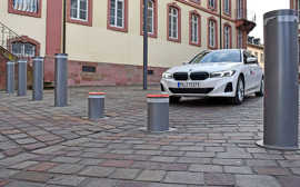 Ein Auto nähert sich einer Pollerlinie mit zwei versinkenden Poller, die ein rotes Signal aussenden