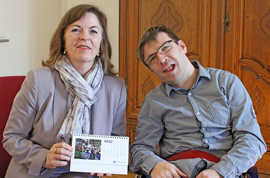 Bürgermeisterin Elvira Garbes mit dem Kalender der Special Olympics, den Reporter Patrick Loppnow ihr geschenkt hat.