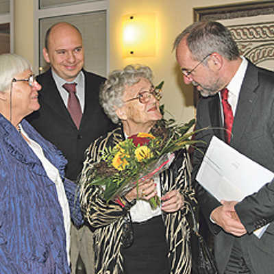 Mit Blumen in den Stadtfarben Rot und Gelb gratulieren OB Klaus Jensen und Ortsvorsteher Dominik Heinrich (2. v. l.) Therese Sappok zum 100. Geburtstag. Die Jubilarin wird von ihrer Tochter Ruthilde begleitet.