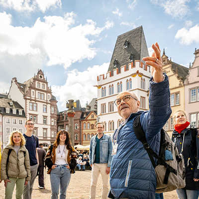 Die Gästeführerinnen und -führer sind auf den Plätzen, Straßen und in den Bauwerken Triers unterwegs und vermitteln ihren Gruppen interessante Fakten und Geschichten über die Stadt. Foto: TTM