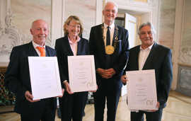 Wolfram Leibe trägt eine goldene Amtskette und steht neben Peter Terges, Sabine Plate-Betz und Christian Pfeil, die ihre Ehrenbriefe präsentieren, 