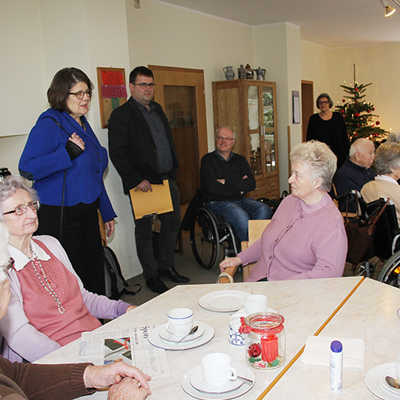 Bürgermeisterin Angelika Birk (hinten Mitte) begrüßt die Senioren in der Olewiger Tagespflegestätte des Club Aktiv. 