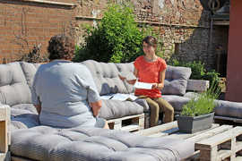 Beratungssituation auf Sofas im Garten