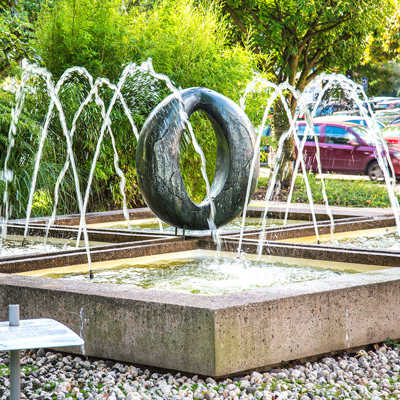 Ein Springbrunnen mit mehreren halbkreisförmigen Fontänen