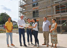 Eine Besuchergruppe besichtigt die Baustelle für das Mehrfamilienhaus Domi