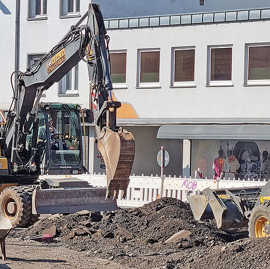 Ein Bagger in Aktion häuft Erde auf.