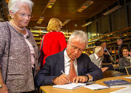 Ulla Hauser lässt sich von Helmut Schröer ihr Exemplar der „Trierer Geschichten“ signieren. 