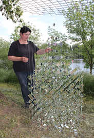 Hedi Schon legt letzte Hand an ihre Arbeit "Wasserspiegel" an. Zahlreiche Spiegelquadrate ergeben die Form eines großen Tropfens, der später hoch oben in einem Baum pendeln wird.