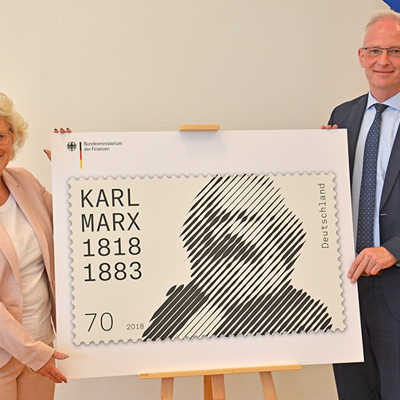 Christine Lambrecht, Staatssekretärin im Bundesfinanzministerium, und OB Wolfram Leibe präsentieren die Sonderbriefmarke Karl Marx in der Beletage des Palais Walderdorff.