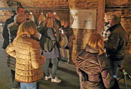 eine Besuchergruppe bei einer Führung durch den Keller der Bischöflichen Weingüter