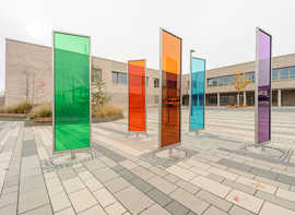 Die Glassäulen mit dem Titel „bunt sehen“ der Künstlerin Birgit Schuh bringen auf dem Schulhof Farbe ins Spiel.