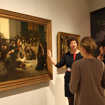 Kathrin Schug vom Stadtmuseum Simeonstift erklärt zwei Besucherinnen ein Bild, das eine Szene im Pfandhaus darstellt.