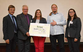 Robert Spreter, Geschäftsführer "Kommunen für biologische Vielfalt" (l.), und Deliana Bungard (Deutscher Städte- und Gemeindebund, r.) überreichen das Label „Stadtgrün naturnah“ in Silber an Baudezernent Andreas Ludwig, Christine-Petra Schacht (Leiterin Stadtgrün Trier) und Christian Thesen (Mitarbeiter Stadtgrün Trier). Foto: Sascha Engst Robert Spreter, Geschäftsführer "Kommunen für biologische Vielfalt" (l.), und Deliana Bungard (Deutscher Städte- und Gemeindebund, r.) überreichen das Label „Stadtgrün naturnah“ in Silber an Baudezernent Andreas Ludwig, Christine-Petra Schacht (Leiterin Stadtgrün Trier) und Christian Thesen (Mitarbeiter Stadtgrün Trier). Foto: Sascha Engst