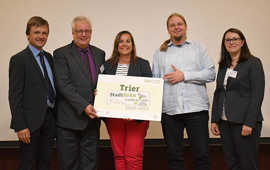 Robert Spreter, Geschäftsführer "Kommunen für biologische Vielfalt" (l.), und Deliana Bungard (Deutscher Städte- und Gemeindebund, r.) überreichen das Label „Stadtgrün naturnah“ in Silber an Baudezernent Andreas Ludwig, Christine-Petra Schacht (Leiterin Stadtgrün Trier) und Christian Thesen (Mitarbeiter Stadtgrün Trier). Foto: Sascha Engst