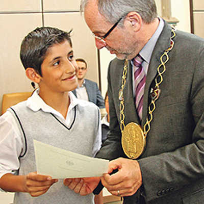Oberbürgermeister Klaus Jensen gratuliert Diyar Akgül aus der Türkei zu seiner deutschen Staatsbürgerschaft. Im Rathaussaal überreicht er dem jungen Trierer seine Einbürgerungsurkunde.