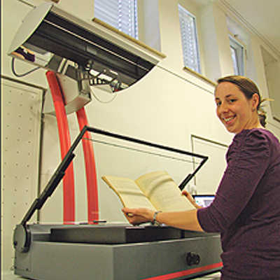 Am Scanner in der Stadtbibliothek digitalisiert Mitarbeiterin Sabine Scholzen den Handschriftenbestand des Klosters St. Matthias. Die Manuskripte sind ab 1. August im Netz frei verfügbar.