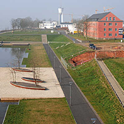 Das Gelände am Wasserband, eine Hauptattraktion bei der LGS 2004 verändert grundlegend sein Gesicht:  Gegenüber den Wohnhäusern (links) hat der Bau des Gebäudes der Firma Telenotwerk begonnen.