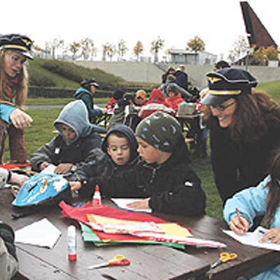 Kreativworkshop auf dem Petrisberg: Dani Ziem (3.v.l.) und Anke Oswald von der mobilen Spielaktion (2.v.r.) tragen als Leiterinnen der Flugschule „Sausewind“, für die die Kinder die Drachen bauten, eine Kapitänsmütze.