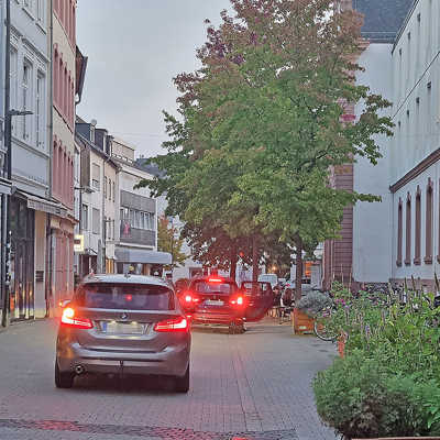 Frühmorgendlicher Verkehr vor dem Angela-Merici-Gymnasium in der Neustraße. Die Umwandlung der Straße in eine Fußgängerzone soll jetzt zügig umgesetzt werden.