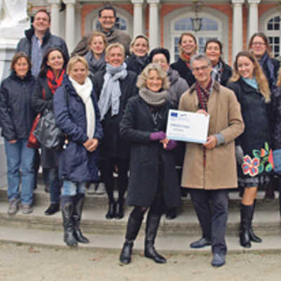 Die deutsch-niederländischen Bildungsexperten präsentieren vor dem ADD-Dienstsitz im Kurfürstlichen Palais die Urkunde für ihr neues Projekt. Foto: ADD