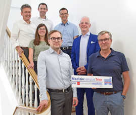 Gruppenbild mit sieben Personen auf einer Treppe