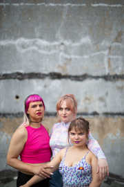 Die drei Mitglieder des „Get over it Collective“ posieren im Bühnen-Outift vor einer Mauer