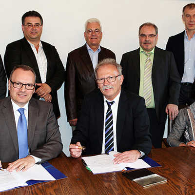 SWT-Vorstand Arndt Müller und Otmar Rößler (Stadtbürgermeister Schweich, vorn, v. l.), unterzeichnen den Vertrag im Beisein von Anita Kruppert (Beigeordnete der Stadt Schweich, rechts). Foto: SWT