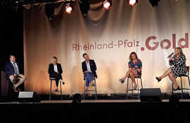 Podium mit verschiedenen Teilnehmenden.