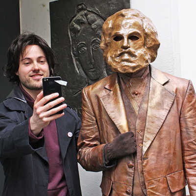 Die Marx-Statue am Simeonstiftplatz avancierte schnell zu einem beliebten Selfie-Motiv. Schauspieler Tobias Schweiger (l.) greift dieses Phänomen in dem Mitgeh-Theaterstück „Marx! Love! Revolution!“ auf, das auch 2019 auf dem Programm der TTM steht.