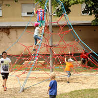 Kinder entdecken die Kletterspinne des neuen Spielplatzes