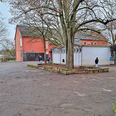 Der Schulhof im Stadtteil Heiligkreuz ist mit den großflächigen Schäden am Asphaltbelag kein Einzelfall. Die Neugestaltung soll auch die ökologische Qualität der Freiflächen verbessern.